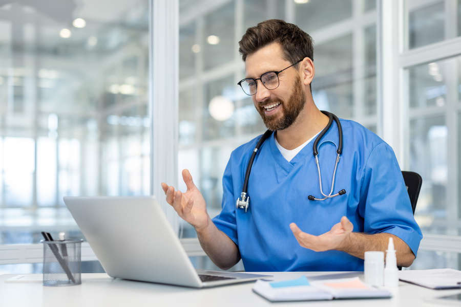 Smiling doctor in medical uniform conducting an online consultation